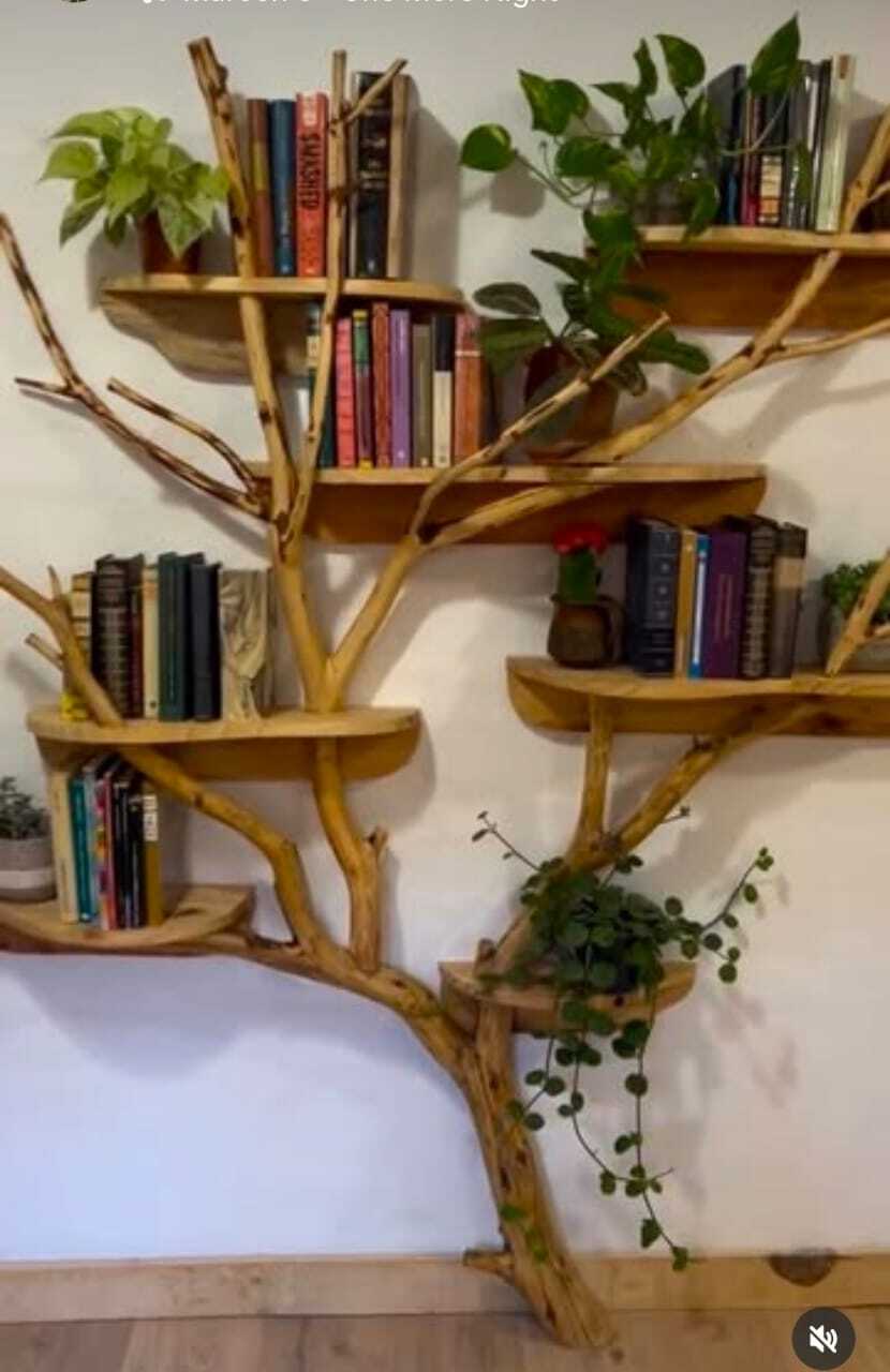 Rustic wooden tree-branch wall shelf with books and plants