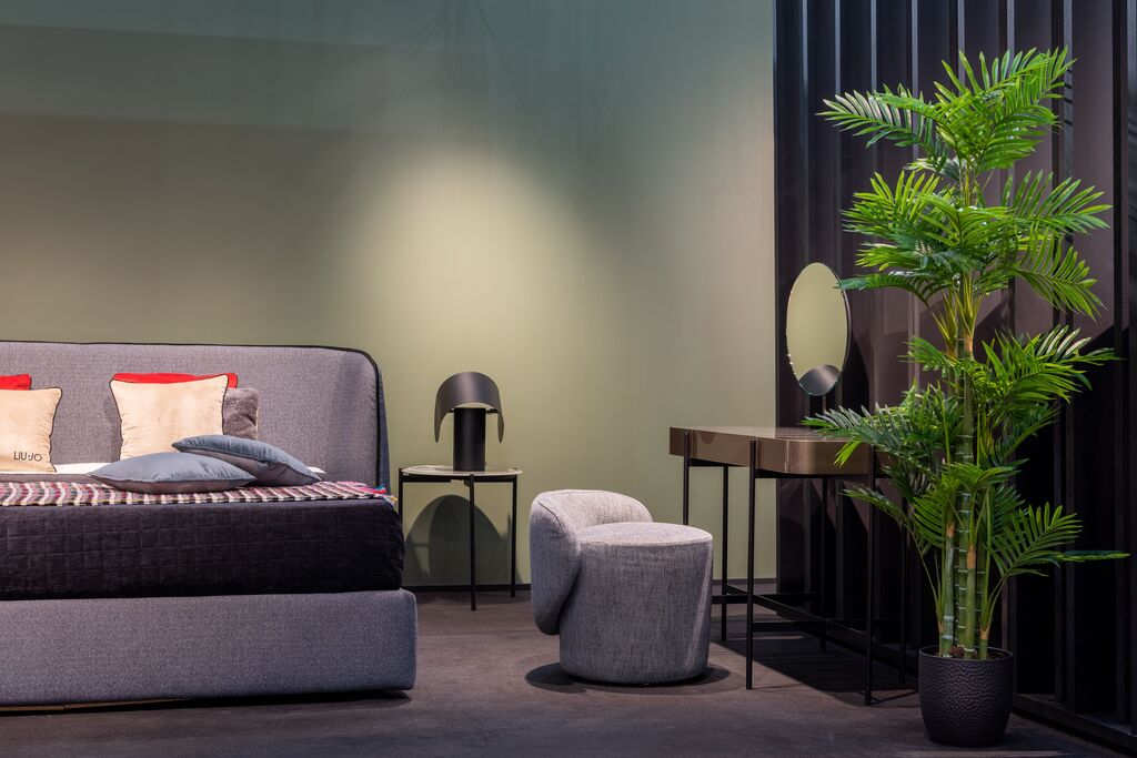 Modern bedroom with a large potted plant beside the bed
