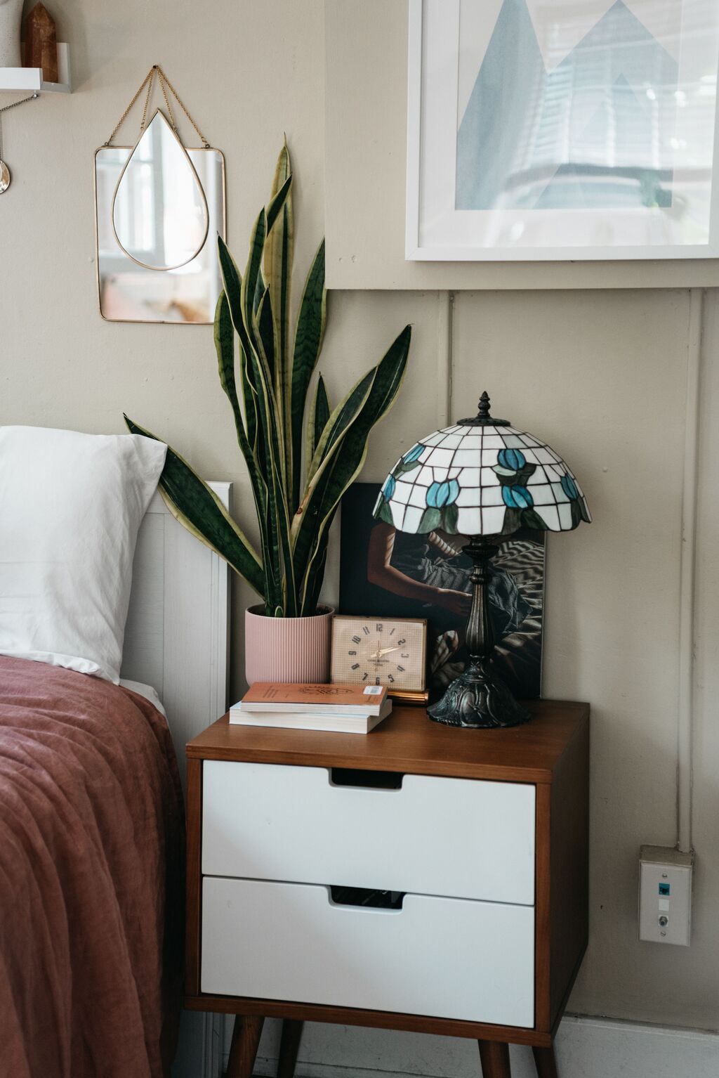 Potted plant and lamp styled on a bedroom nightstand